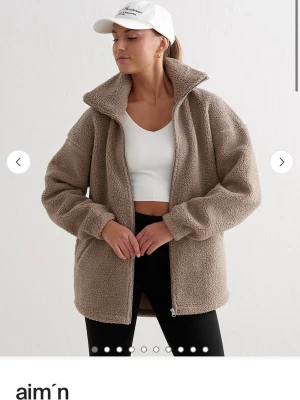 Beige teddyjacka från aim'n - Mysig beige teddyjacka från aim'n med hög krage och dragkedja framtill. Jackan har två sidofickor med dragkedja och en avslappnad, oversized passform. Helt ny, prislapp och paketet jag fick de i är kvar, aldrig använd! 1300kr nypris!