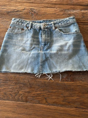 Blå jeanskjol från Replay - Cool kort jeanskjol från Replay med klassisk femficksdesign och rå, fransig nederkant. Ljusa blå toner och slitningar ger en avslappnad vibe. Bakficka med röd broderad detalj och Replay-läderpatch i midjan. Perfekt för dig som gillar denim och streetstyle. Pris kan diskuteras ❤️