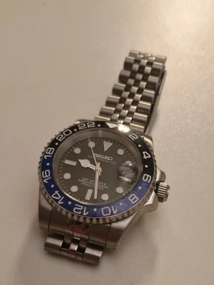 Seikomod GMT Batman - Säljer en helt nybyggd seiko med ett atomistiskt nh34 urverk. Telescope boett, se bild 4, samt datumvisare. Länkar och skruvmejsel medföljer så man kan justera armbandet. Hör av er för fler bilder eller frågor. Pris kan diskuteras.