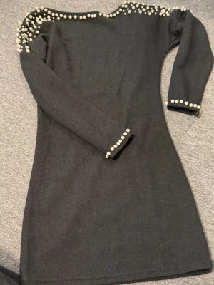 Kort klänning med pärlor - Använd vid 1 tillfälle. Kort med öppen rygg. Super söta pärlor. Köpt utomlands men det står ej någon storlek. Skriv för mått men gissar på S