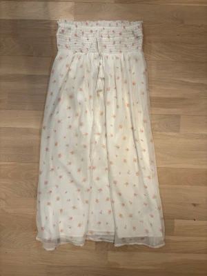 Vit långkjol med blommigt mönster - Jättefin vit kjol med små rosa gulliga rosor på. Den är storlek 146-152 från Gina tricot, den är stor i storleken så den passar även lite större. 