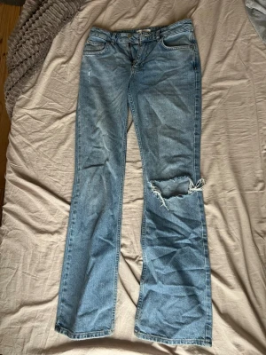 Jeans blåa - Blåa jeans med hål vid knäet