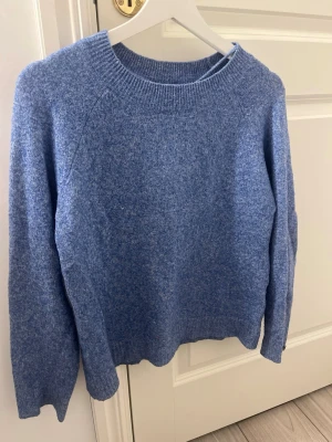Blå stickad tröja med rund hals - Mysig blå stickad tröja från vero moda. Tröjan har en enkel och stilren design.Perfekt för lager-på-lager och chill dagar.