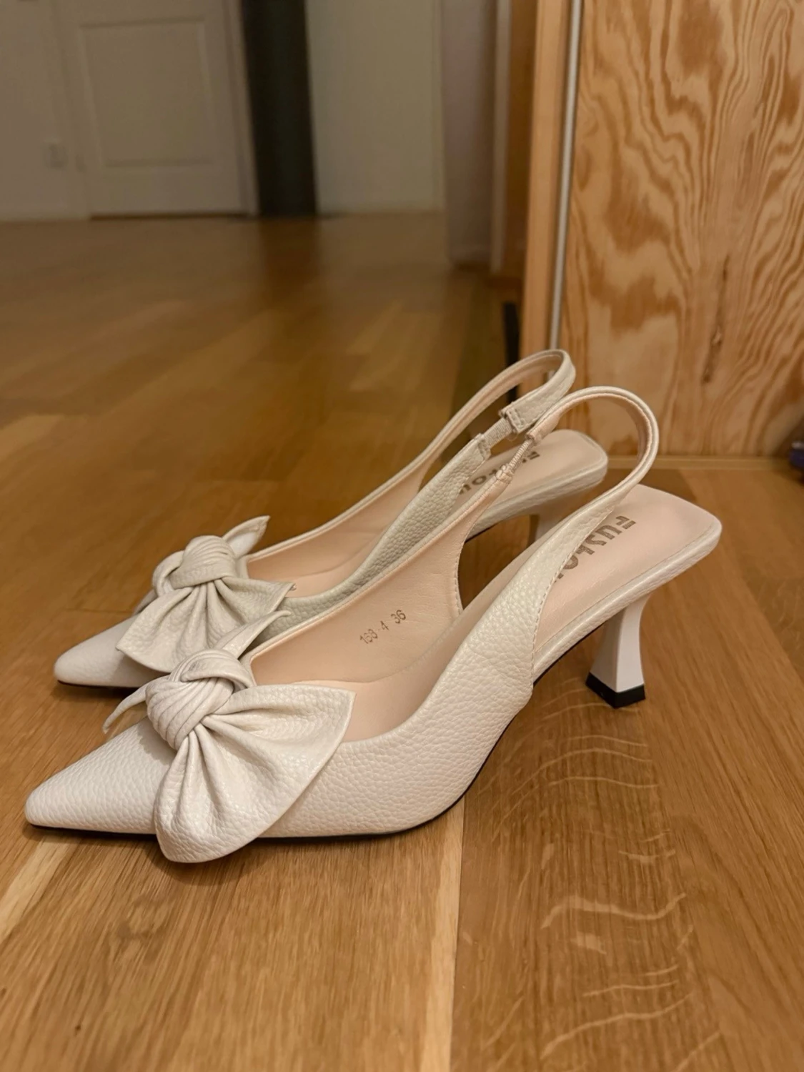 Vita pumps med rosett.