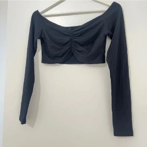 Svart croppad offshoulder topp - Svart ribbad croppad topp från NLY One. 