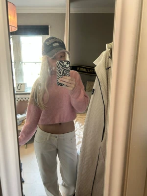 Rosa croppad stickad tröja - Säljer en supermjuk, croppad stickad tröja i ljusrosa. Tröjan har rund halsringning, långa ärmar och ribbade muddar. Perfekt för dig som gillar en trendig och avslappnad stil. Materialet känns fluffigt och bekvämt.