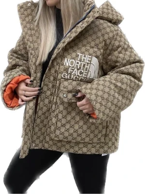 Beige pufferjacka The North Face x Gucci - Säljer en beige pufferjacka från The North Face x Gucci med ikoniskt GG-mönster över hela jackan. Jackan har stor huva, orange innerfoder och stor logga på bröstet. Två stora fickor framtill och oversized passform. Perfekt för dig som vill sticka ut i vinter.