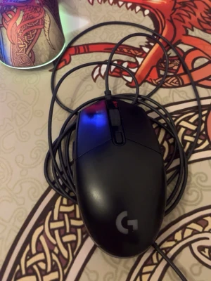 Logitech G203 LIGHTSYNC gamingmus - Säljer en svart Logitech G203 LIGHTSYNC gamingmus med sladd. Musen har RGB-belysning och en klassisk, ergonomisk form som passar bra för gaming. Tillverkad i plast och har Logitechs logga på ovansidan.