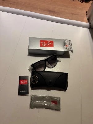 Svarta Ray-Ban boyfreind solglasögon - Säljer mina Klassiska svarta Ray-Ban boyfreind solglasögon för de inte kom till användning. Säljes med originalfodral, putsduk och box. Köptes från synsam så har även kvitto.