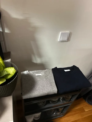 Grå och marinblå tröja Grunt - •Två stilrena tröjor från Grunt en i ljusgrått och en i marinblått.                                                                      •Båda tröjorna är i jätteskönt material.                             •Storlek: XL i barn men passar som Xs till herr. 🔱