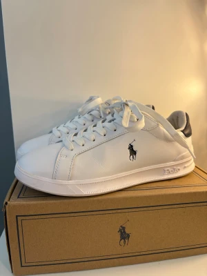 Vita Polo Ralph Lauren sneakers - Säljer ett par sneakers från Polo Ralph Lauren i ett bra skick, använda 2 gånger och kommer inte mer till användning där av säljer jag dem. Köptes på Zarlando för 1600kr säljer för 1000kr så de är bra skick på dem. De ända små deffekterna syns på de två sista bilderna (på vänstra skon) Orginal box med följer. 