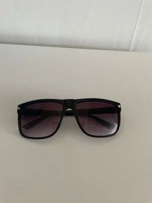 Solglasögon  - Schyssta svarta solglasögon som inte har något tecken på användning.