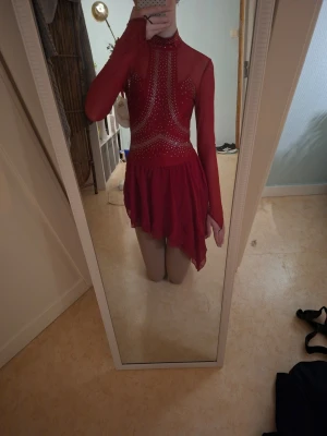Röd konståkningsklänning med kristaller - Säljer denna ikoniska konståkningsklänning i strl S från märket iEFiEL. Köpt från Joom för 220kr. Säljer pga jag har nytt program och ny klänning. Använd 1 gång på tävling så den är nästan helt ny. 