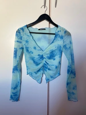 Blå långärmad topp - Långärmad topp i himmelblå som är tunn och lätt i materialet.