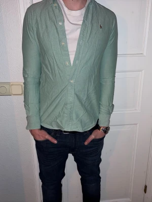 Ljusgrön skjorta från Ralph Lauren - Ljusgrön skjorta från Ralph Lauren i storlek S.  Fint skick till ett bra pris. Nypris: 1995kr. Mitt pris: 349kr. Vid frågor eller funderingar, tveka inte att höra av dig.
