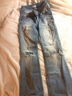 Ljusblå slitna bootcut jeans - Ljus blå jeans med hål på knäna. Väldigt fina nu till våren. Bra skick (lite skrynkliga på bilden, annars väldigt bra skick och material). Hör av er vid frågor🩵💙