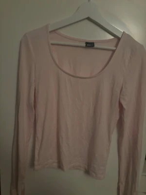 Ljusrosa långärmad topp Gina Tricot - Söt ljusrosa långärmad topp från Gina Tricot med rundad urringning. Enkel och stilren design som passar perfekt till jeans eller kjol. Mjuk och skön känsla, perfekt för dig som gillar basic-plagg med en feminin touch.