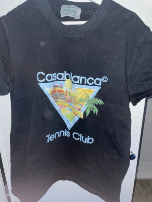 Svart Casablanca Tennis Club t-shirt - Snygg svart t-shirt från Casablanca med färgglatt tryck och texten 'Tennis Club' på bröstet. Klassisk rund hals och korta ärmar. Perfekt för dig som gillar streetwear och vill sticka ut med en unik design. PRIS KAN DISKUTERAS‼️