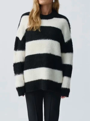 Svartvit randig stickad tröja - Säljer en stickad tröja med breda svarta och vita ränder. Tröjan har en rund halsringning och långa ärmar. Materialet är mjukt och fluffigt, perfekt för att hålla sig varm. Passar dig som gillar en cool och avslappnad stil. Nypris: 499kr