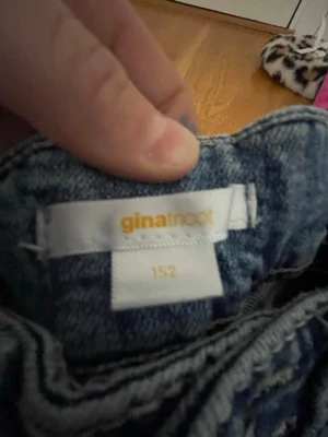 Gina Tricot jeans med svensk flagga - Unika blå jeans från Gina Tricot i storlek 152 med en handmålad svensk flagga på bakfickan. Klassisk femficksmodell i denim med cool tvätt och raka ben. Perfekta för dig som vill sticka ut och visa din stil! 