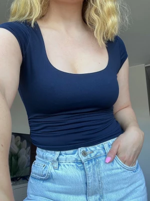 Croppad marinblå y2k rouched minimalist topp - Marinblå croppad topp med rundad urringning. Mycket stretchig och sitter smickrande tight på kroppen. Tidlös. Sparsamt använd!