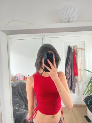 Röd croppad linnetopp med snörning - Aldrig använd. Bor i Danmark, skickar till alla länder