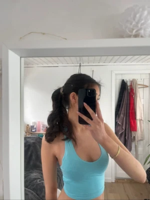 Turkos halterneck - Turkos topp med öppen rygg. Aldrig använd. Bor i Danmark och skickar till alla länder.