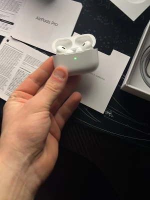 Apple AirPods Pro med laddningsetui - Trådlösa vita AirPods Pro från Apple med aktiv brusreducering och laddningsetui. Snygg och kompakt design i matt plast, perfekt för musik och samtal. Levereras med originalförpackning och tillbehör.