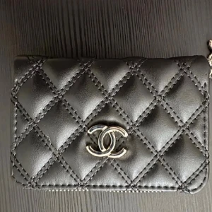 Plånbok med silvriga detaljer  - Plånbok med silvrigt märke och silvrig dragkedja. Fack för kort och sedlar. Ca 13cm bred och 9cm hög. Lapp kvar, kommer med box också.