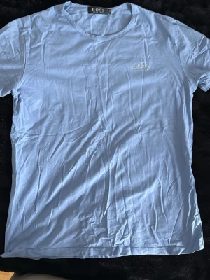 Ljusblå t-shirt från Hugo Boss - Snygg ljusblå hugo boss t-shirt. Lite skrynklig men går att stryka så är den som ny. Säljer billigt då jag rensar min garderob