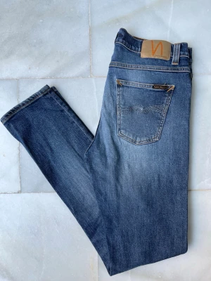 Blå jeans från Nudie Jeans - Riktigt snygga blå jeans från Nudie Jeans i fint skick. Modellen är Lean Dean. 😁—————————————————————————— 📐| Storlek: 29-32                                                  👖| Märke: Nudie Jeans                                         🔎 | Skick: Fint skick                                               💵 | Ny Pris: 1599kr                                                 ✍🏻 | Skriv om du har några frågor