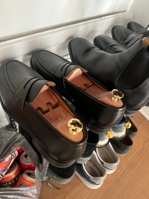 Svarta loafers från Myrqvist - Säljer ett par klassiska svarta loafers i storlek 9 (UK) från Myrqvist i  läder. Skorna har en stilren penny strap och rundad tå. Perfekta för dig som gillar tidlös och clean stil. Helt nyköpta, säljer pga köpte fel storlek. Träskoblock ingår ej. 