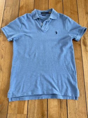 Ralph lauren piké - Säljer en Ralph lauren piké som är i väldigt bra skick. Använts några gånger men säljer nu för den inte passar mig så bra längre. Färgen är ljusblå. Skriv vid fler frågor!