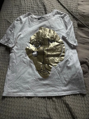 Vit t-shirt med guldtryck - Säljer en vit t-shirt ifårn Zara storlek S då den inte kommer till någon andväning.