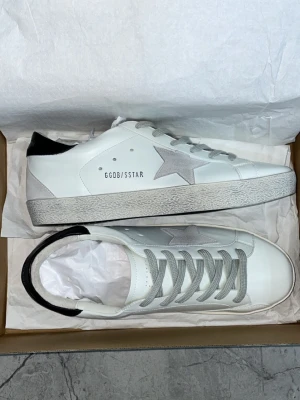 Vita Golden Goose sneakers med stjärna - Hej, säljer dessa Golden goose i storlek 43. Helt nyskick. Aldrig använd. Passar också storlek 42! Priset kan självklart diskuteras ☺️bara skor medföljer vid köp