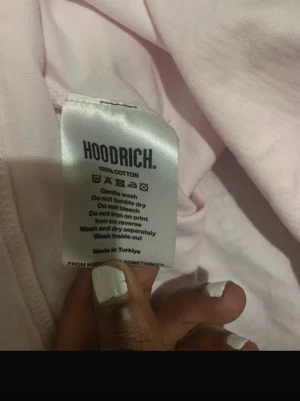 Ljusrosa t-shirt från Hoodrich - Säljer en ljusrosa t-shirt från Hoodrich i 100% bomull. Klassisk rund halsringning och enkel design utan tryck på framsidan. Perfekt basplagg för dig som gillar streetwear och stilrena detaljer.