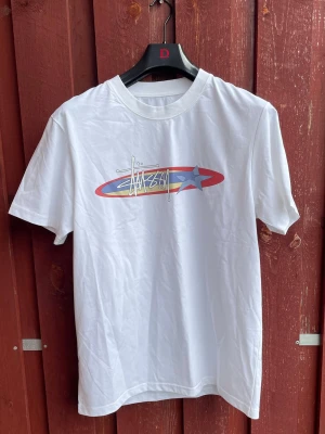 T shirt med Stussy tryck - Vit tshirt med Stussy print. Saknar tagg i nacken, storlek L herr
