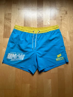 Nocco Limon del Sol badbyxor Limited edition strl M - Säljer dessa limited edition badbyxor från Nocco i storlek M. Trycket har lite slitningar, se bilder.
