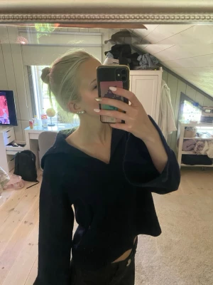 Mörkblå oversized tröja med krage - Säljer en mörkblå tröja med bred krage och långa, vida ärmar. Tröjan har en avslappnad passform och är perfekt för dig som gillar en chill och trendig stil. Materialet ser mjukt och bekvämt ut, perfekt att mysa i under kyligare dagar. Säljes då den ej kommer till användning