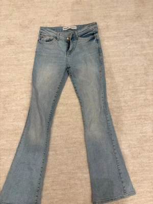 Ljusblå bootcut jeans - Jeans lågmidjade bootcut. Liten rosa fläck på de men annars bra kvalité. Storlek 32. 