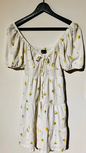 Trendig Gina Tricot citronklänning milkmaid stl S 🍋✨ - Säljer denna supersöta milkmaid-klänning från Gina Tricot i storlek S! Den har puffärmar med bra stretch som man kan ha off-shoulder, söt rosett/knytning i bysten och en stretchig rygg som gör att den sitter jättebekvämt. crinklat material med skön stretch och har ett mjukt underfoder så den inte syns igenom. Sitter otroligt fint på. Mått när den ligger platt: * Bredd: ca 41–42cm * Midja: ca 26–27cm (stretchig resår) * Längd: ca 83–84cm Ansvarar inte för postens slarv🫶