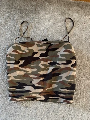 Camouflage mönstrad linnetopp - Säljer ett camouflage färgat linne från Gina Tricot strl L men skyller säga att den är mer M/S i storlek. Inga slitningar etc 🩷 
