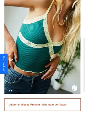 Grön ribbad linnetopp med spets - Trendig grön ribbad linnetopp med tunna ljusgula axelband och dekorativa spetsdetaljer i samma ton. Toppen är croppad och har en feminin v-ringning med spets längs kanterna. Perfekt för sommarens alla outfits.