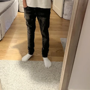 Nudie Jeans Skinny Lin - Säljer ett par svarta/gråa Nudie Jeans storlek 28/30. Jeansen har klassisk femficksdesign, svarta sömmar på bakfickorna och en snygg tvättad look. Tillverkade i stretchig bomullsdenim för en slim passform. Köpta i butik. Mycket bra skick (10/10). Inga defekter.