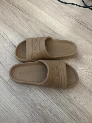  Tofflor  - Säljer ett par beigea slides från GANT. Storlek 38