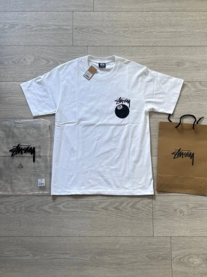 Stussy / Stüssy t-shirt - Helt ny t-shirt från Stüssy med svart 8-ball tryck och logga på bröstet samt tryck på ryggen. Klassisk passform och rund hals. Perfekt för sommaren och dig som gillar streetwear. Papperspåse och plastpåse ingår! Kom gärna med frågor!😁