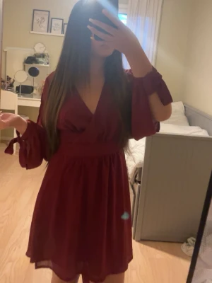 Vinröd omlottklänning🍷 - Säljer en söt och elegant klänning som passar till sommaren, perfekt till fest eller finare tillfällen. Med markerad midja som det finns knytdetaljer och så är det långa ärmar med öppen slits och knytdetaljer vid handlederna. 