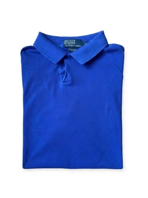 Blå polotopp från Polo Ralph Lauren - Snygg blå polotopp från Polo Ralph Lauren med klassisk krage och korta ärmar. T-shirten har diskret broderad logga på bröstet och är tillverkad i mjuk bomull. Perfekt för dig som gillar stilrena och tidlösa plagg.