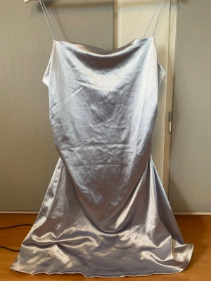 Silvrig silkesklänning - Säljer en silvrig/blå silkesklänning från H&M. 