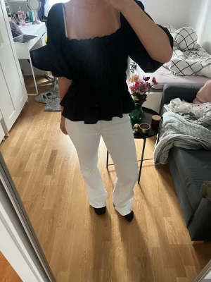 Vita bootcut jeans - Säljer ett par vita jeans med utsvängd passform . Jeansen har klassisk femficksdesign och är tillverkade i ett denimtyg. Perfekta att matcha med olika toppar och sommaren! 